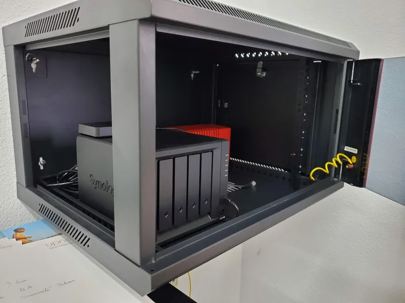 Wall-mounted communications cabinet with a Synology NAS server