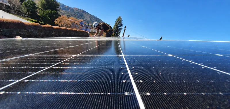 Technician installing rooftop solar panels